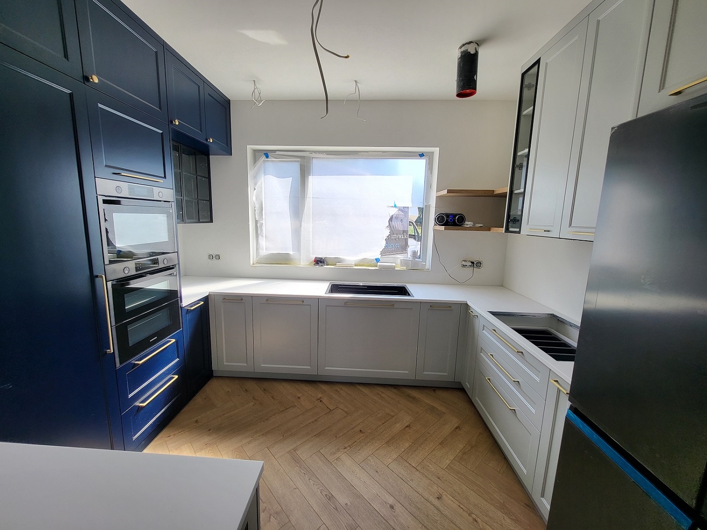 Biały blat solid surface w kuchni L/U: spokój formy, który robi całe wnętrze